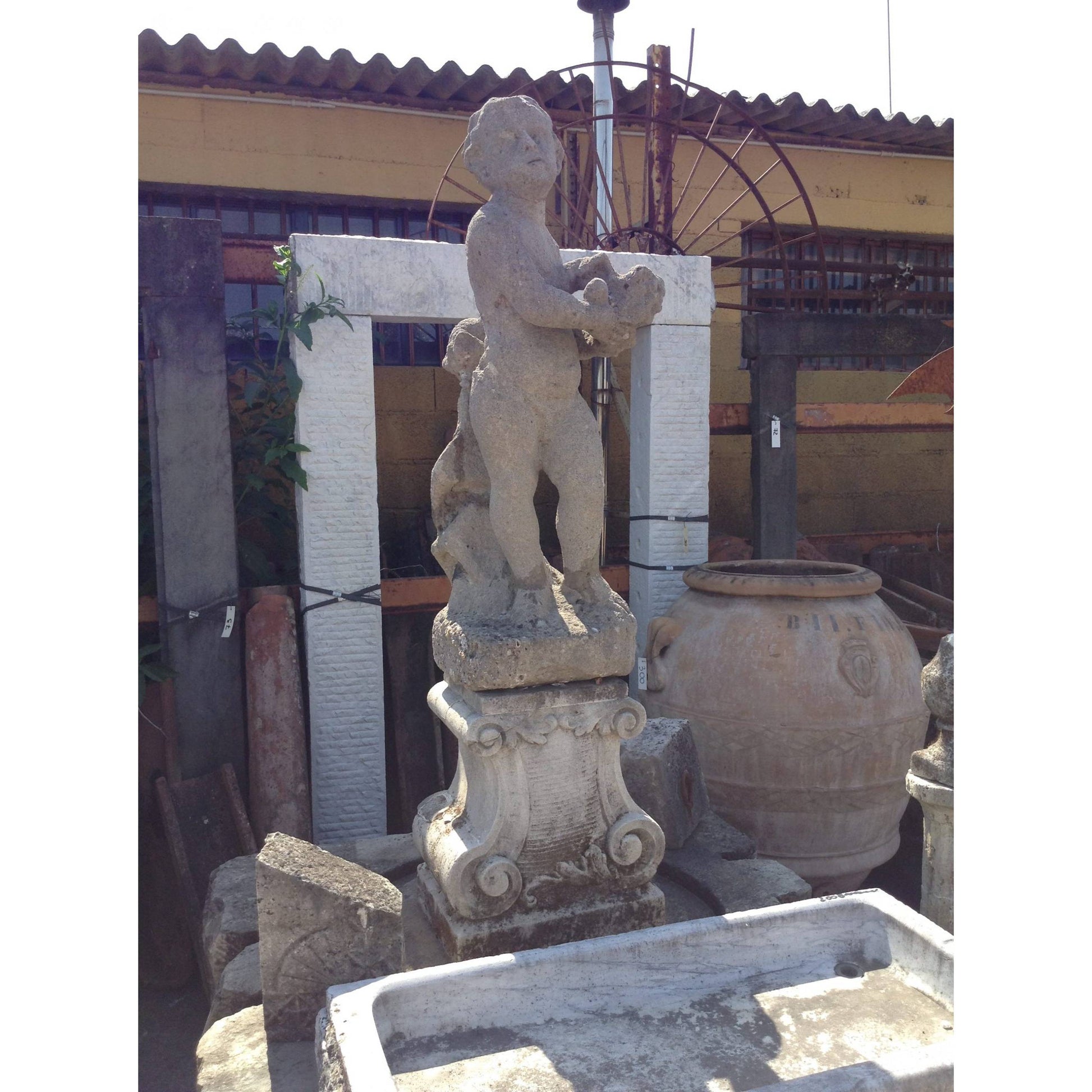 Statua in pietra raffigurante putto 