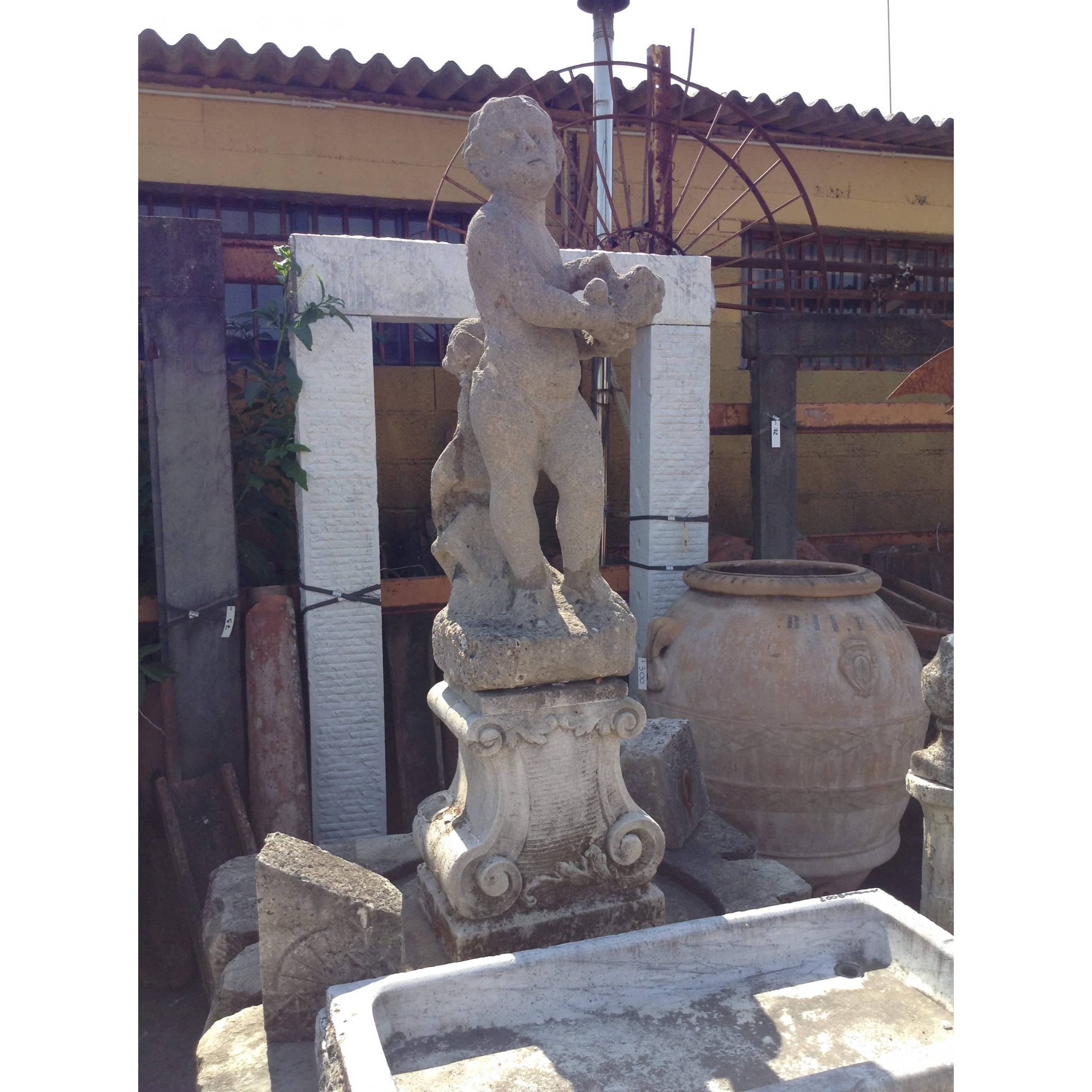 Statua in pietra raffigurante putto 